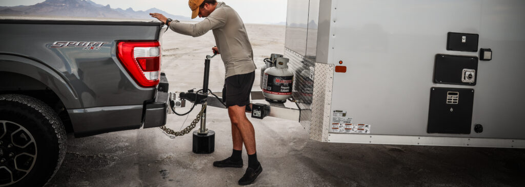 man connecting trailer to trailer hitch ball mount