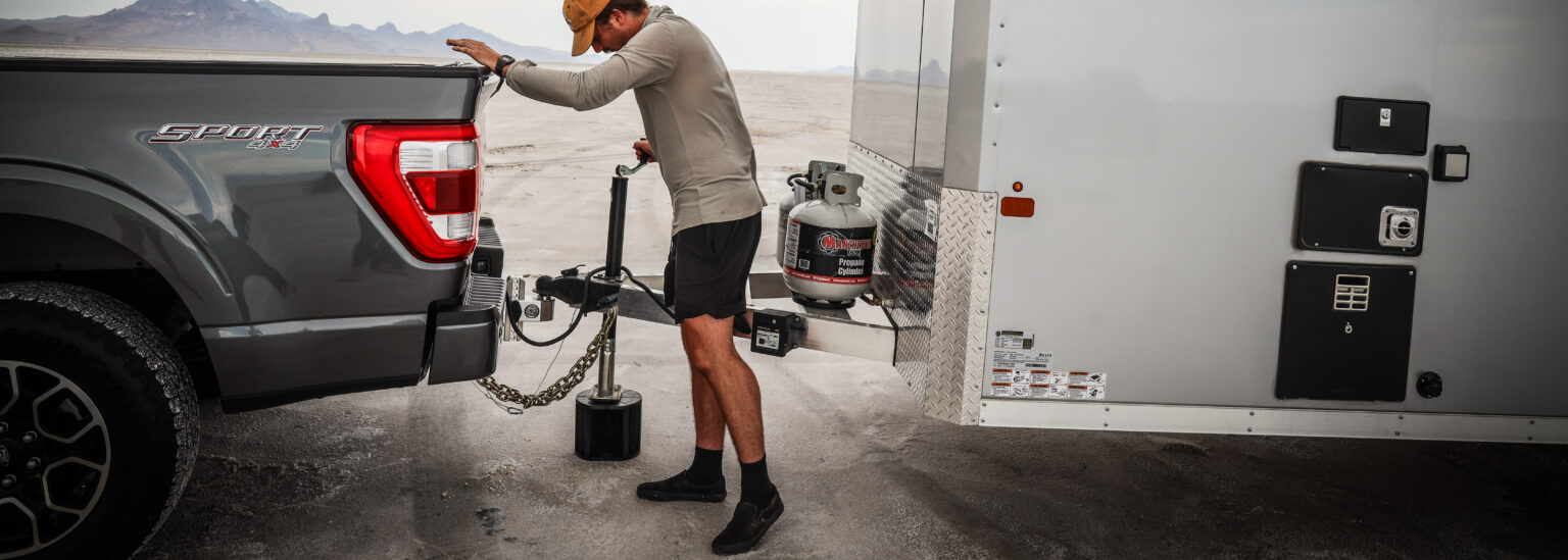 man connecting trailer to trailer hitch ball mount